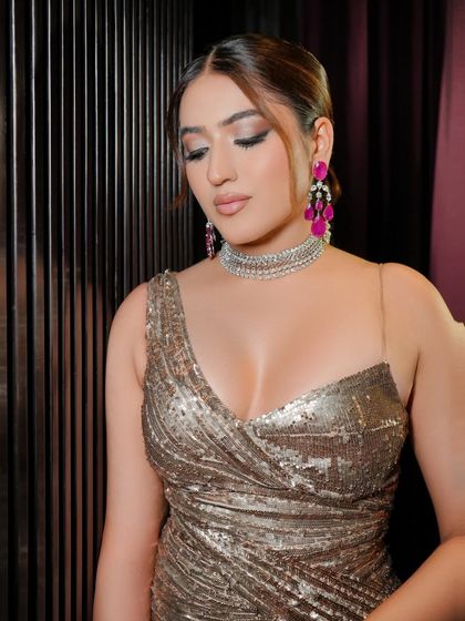 A close-up of the welcome dinner makeup. The look features a soft yet defined smoky eye, beautifully contoured cheeks, and a neutral lip, allowing the sparkling dress and ruby earrings to pop.