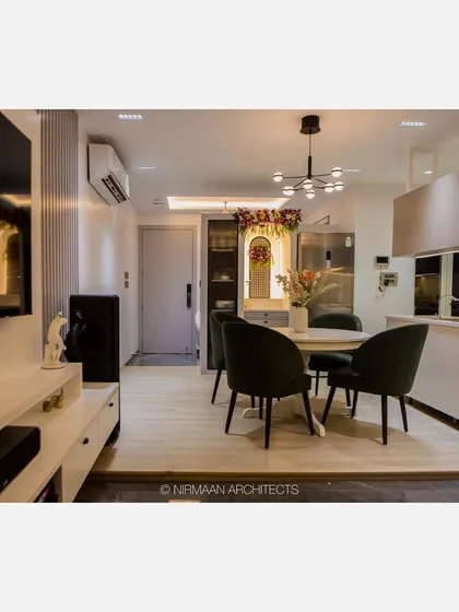 An open-plan living and dining area in our Bhagwati Greens project. The island kitchen flows into the dining space, which is defined by a modern chandelier and comfortable seating.