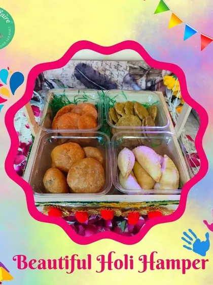 A beautiful Holi hamper featuring a four-section tray filled with Dal Kachori, Spinach Mathri, Beetroot Mathri, and Desi Ghee Gujiya.