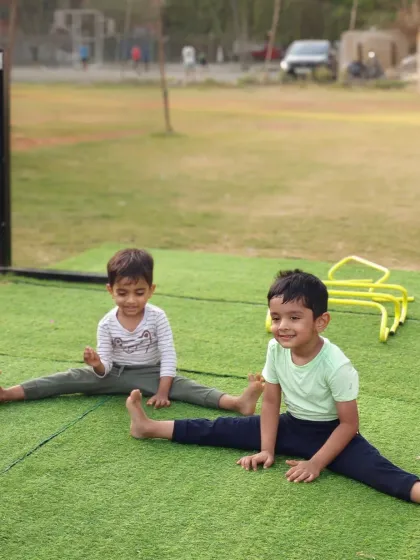 Working on their straddle stretch. These two friends make flexibility training fun, motivating each other to improve their range of motion.