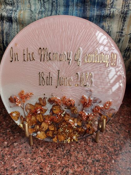 Another view of the memorial keepsake. The soft pink background and preserved flowers create a gentle and peaceful feeling. It is designed to be a comforting reminder of a cherished life.
