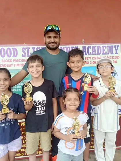 A group of our youngest tournament winners with their coach. Their smiles show the joy of competition and the pride of winning.