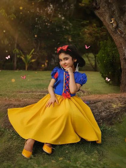 A classic portrait of our Snow White sitting gracefully in the woods. The vibrant colors of her dress stand out beautifully against the natural green backdrop.