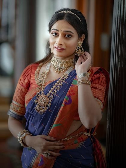A close-up of the model, her traditional jewelry and elegant pose highlighting the beauty of the Paithani saree.