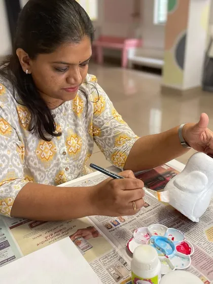 A participant carefully paints her penguin planter, enjoying a relaxing and creative session at our studio.