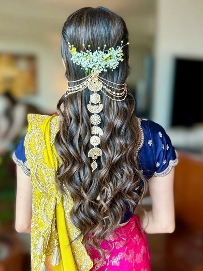 A full back view of the 'Myra' look, showing the placement of the baby's breath and the cascading gold accessory.