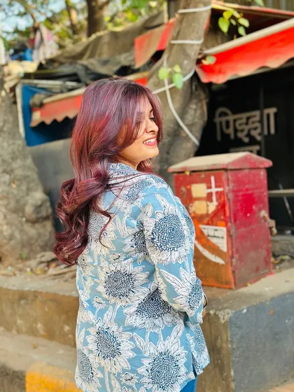 A fun, candid shot of the client enjoying her new red hair on the streets of Mumbai.