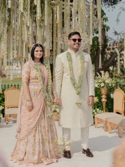 Hand in hand after the ceremony, the couple stands together, ready to begin their new life. The delicate varmalas complement their pastel outfits perfectly.
