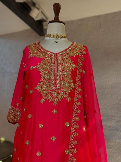A bright pink kurta with heavy gold embroidery around the neckline, perfect for making a statement.