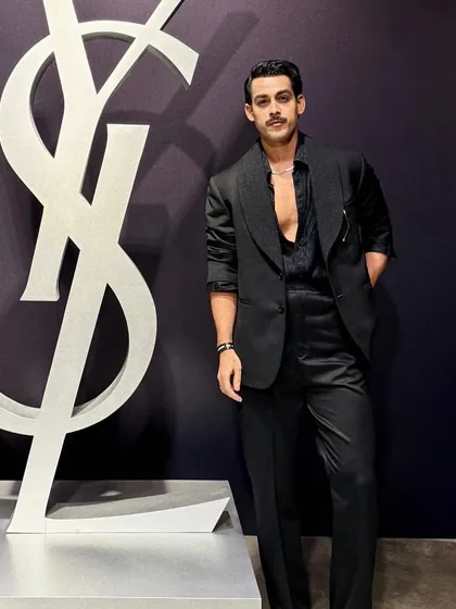 Giri Sawalkar in a sleek, all-black ensemble. The look is built around a subtly textured jacket with a sharp silhouette, embodying a refined and minimalist approach to eveningwear.