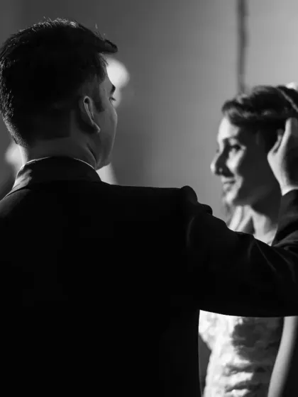A candid, behind-the-shoulder shot that feels like a scene from a classic movie. This black and white portrait captures a private, tender moment.