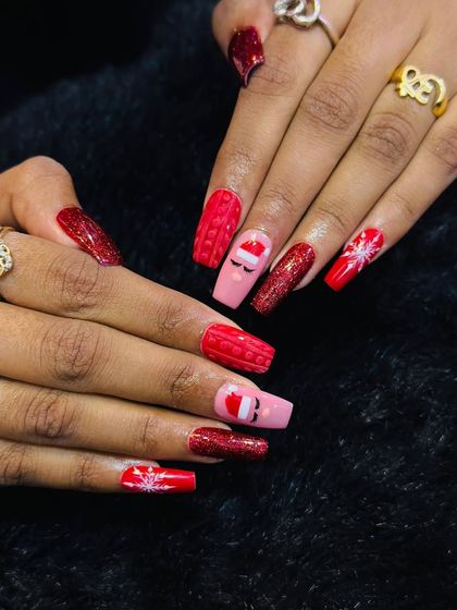Holiday nails that are both cute and festive. This set features bright red glitter, a cozy cable-knit sweater texture, and an adorable winking Santa Claus accent nail.