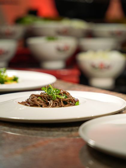 A plate of soba noodles, simply garnished with microgreens. The beauty lies in its minimalism and the promise of clean, authentic flavour.