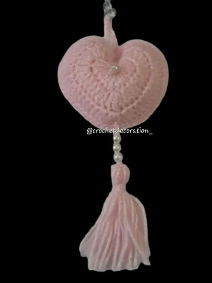 A puffy pink heart keyring with a decorative pearl and tassel. This simple and sweet design makes a lovely gift for Valentine's Day, anniversaries, or just to show someone you care.