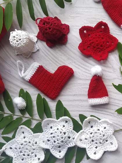 An assortment of our red and white crochet Christmas decorations. Here you can see the variety we offer, from stars and bells to tiny Santa hats and stockings.