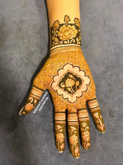 A modern take on engagement mehndi. This design features bold cutwork floral patterns on the fingers and wrist, paired with a delicate central motif, creating a look that is both contemporary and timeless.