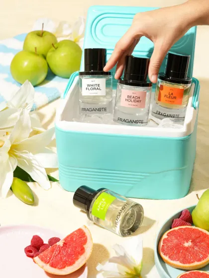 A playful, summery shot of various perfumes in a beach cooler with fresh fruits. This is a great way to photograph a collection and create a seasonal theme.