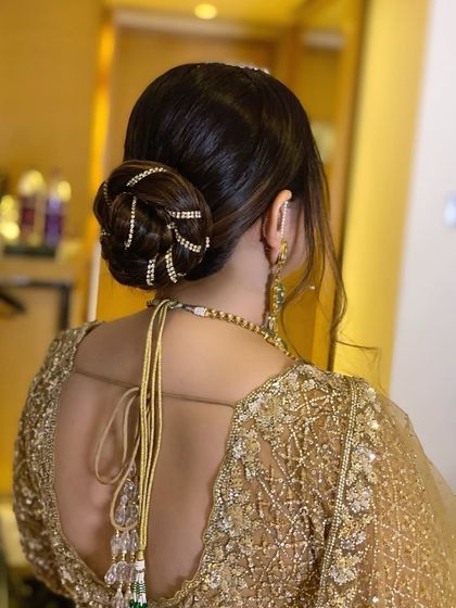 A sleek, roped bun with a sparkling, embellished wrap-around accessory. This is a very glamorous and neat updo, perfect for a reception or black-tie event.