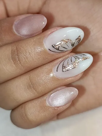 An elegant design with a mix of pearly pink and white nails. The accent nails feature a delicate, hand-painted butterfly wing design with a touch of rose gold foil.