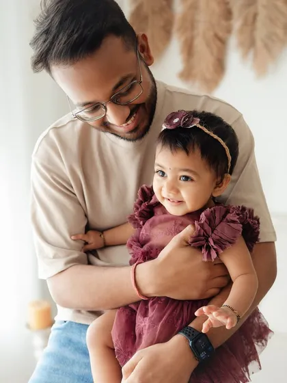 A father's smile says it all. This image captures the pure happiness and pride a dad feels while holding his precious one-year-old daughter.