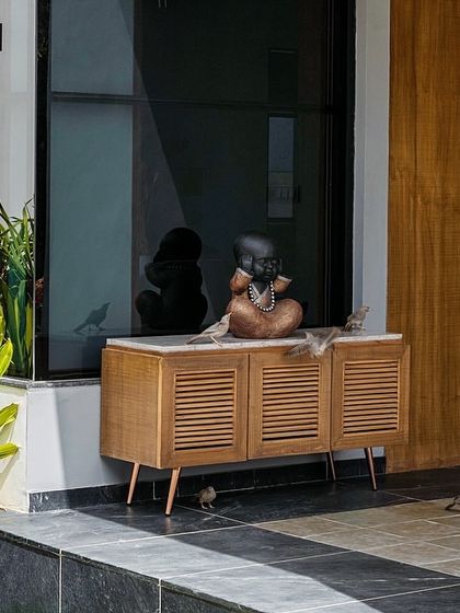 Even small details contribute to the story. At the entrance of 'Tranquil Mango Haven', a simple console table is placed against a large window, blurring the line between the interior foyer and the exterior garden.