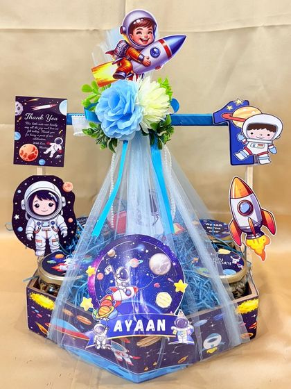 An out-of-this-world galaxy-themed hamper for Ayaan's first birthday, featuring a hexagonal box, net wrapping, and lots of space elements.