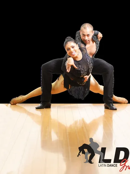 This photo shows a dynamic, low-to-the-ground move that requires great flexibility and partner coordination. It's a great example of the advanced techniques we teach.