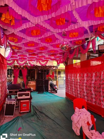 A view of the DJ and sound system setup inside a pandal for a Haldi event. The colorful ceiling decor and side draping create a festive enclosure for the party.
