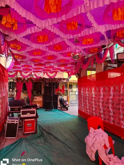 A view of the DJ and sound system setup inside a pandal for a Haldi event. The colorful ceiling decor and side draping create a festive enclosure for the party.