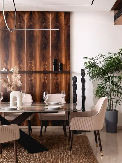The rich grain of the mahogany panels provides a dramatic backdrop for the dining set. We used these panels to add character and define the common areas, much like a dash of cinnamon in a cappuccino.