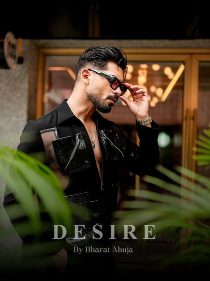 A portrait that captures the sophisticated yet edgy vibe of the black utility shirt. The tinted glasses and confident pose complete the look.