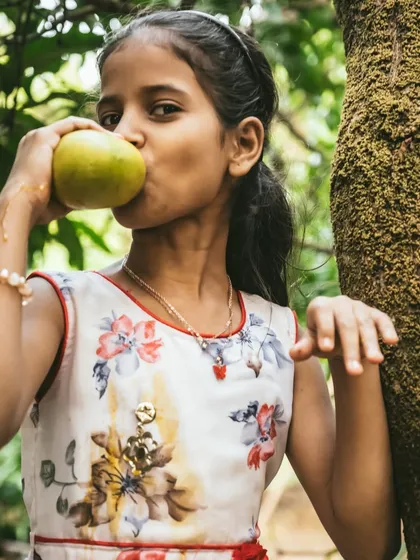 The pure, uninhibited joy of biting into a fresh mango. This close-up shot is powerful and emotional, capturing the essence of the summer mango season.