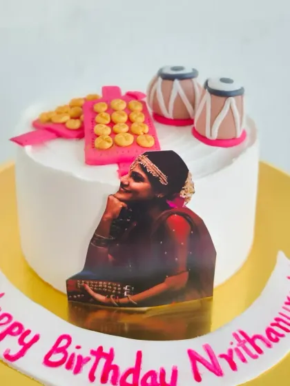 A custom cake for a classical dancer and musician, featuring an edible photo and hand-molded fondant tabla and ghungroo.