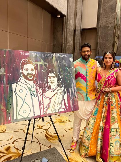 The happy couple with their finished portrait, painted with love by their friends and family during the Mehendi ceremony.