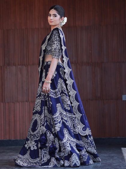 An impeccable look for a housewarming, which could easily be for a reception. The navy blue lehenga is paired with smokey eyes and a flawless base.