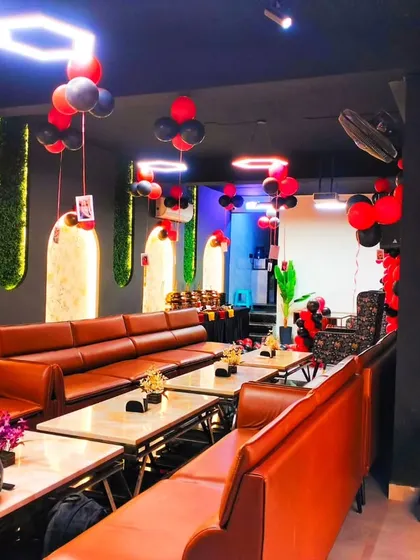 This lounge was decorated with a red and black theme. The balloons are arranged in bunches and hung from the ceiling, adding color to the entire room.