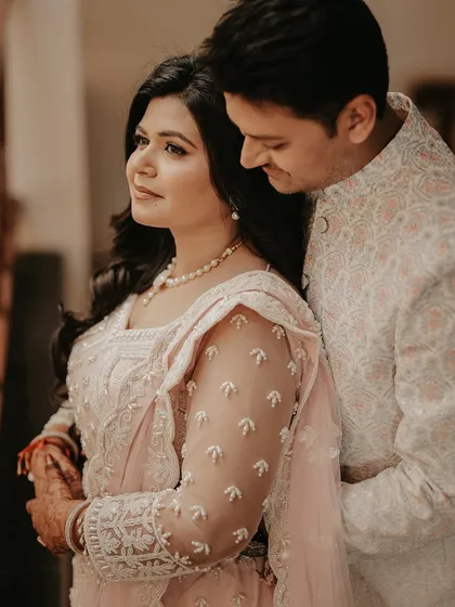 A soft and romantic close-up of the couple. The groom's gentle embrace from behind and the bride's serene expression create a warm and intimate portrait.