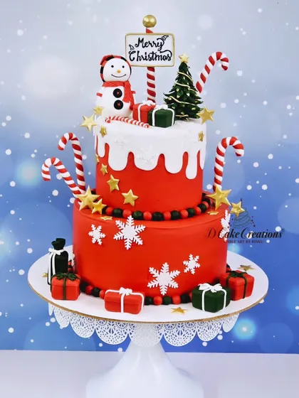 A cheerful two-tier red Christmas cake, adorned with snowflakes, candy canes, and a friendly snowman.