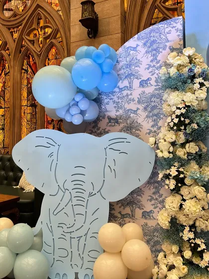 For the arrival of twin boys, we created an elegant animal-themed decor using a sophisticated blue and white toile pattern as a backdrop, paired with custom animal cutouts.