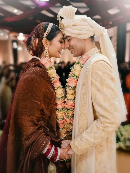A classic, happy portrait of the couple, their foreheads touching in a moment of pure love and connection after their ceremony.
