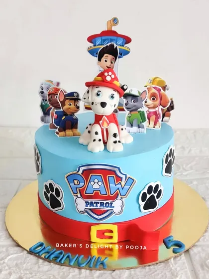 A Paw Patrol cake featuring a handcrafted, 3D fondant Marshall topper, along with the rest of the pup crew. This design is perfect for any little fan of the show.