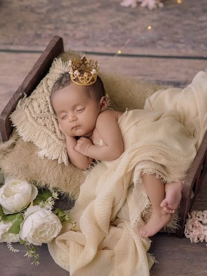 A little king's rest. This setup combines a rustic wooden bed with soft, creamy fabrics and a tiny golden crown for a touch of royalty.