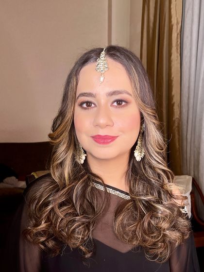 A smiling portrait, showing how the makeup enhances her features beautifully.