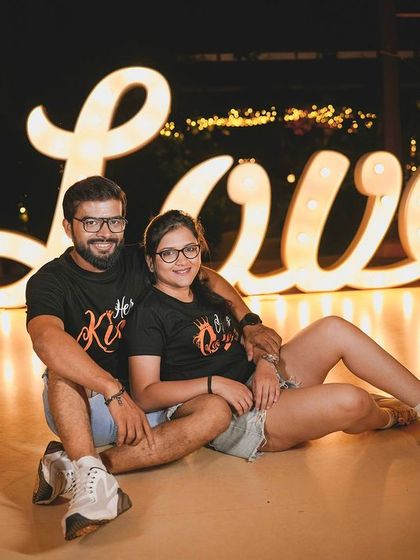 Another fun pose with the 'Love' sign, perfect for capturing a couple's playful dynamic.