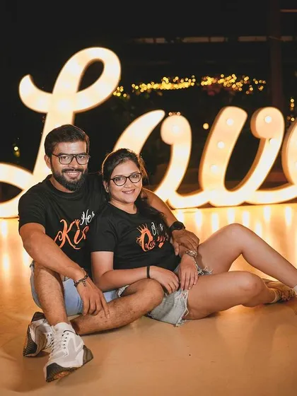 Another fun pose with the 'Love' sign, perfect for capturing a couple's playful dynamic.