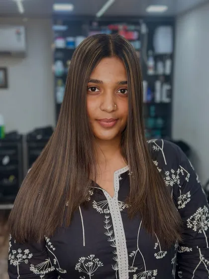 A beautiful, confident client showing off her fresh, straight hair with perfectly blended highlights. The art of the highlight is in the details.