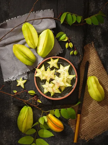 The unique star shape of this fruit is the hero of the shot. This flat lay composition is designed to showcase that feature, making it a visually interesting product photograph.