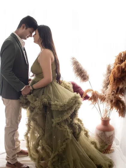 A romantic silhouette against a bright window. This artistic shot from a maternity session highlights the couple's connection in a beautiful, simple way.