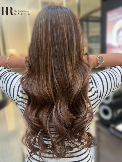 The back view of a stunning balayage on long hair, where the color flows seamlessly from dark to light.