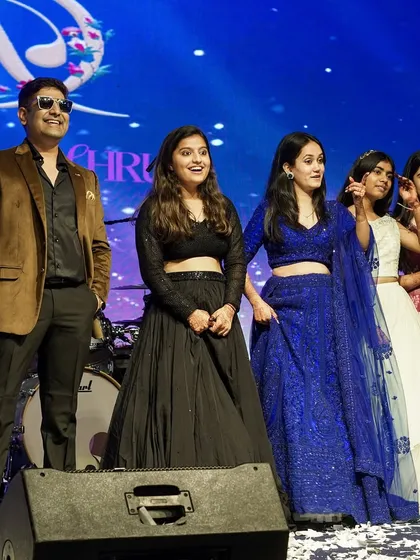 A group photo with guests on stage. These moments are all about celebrating the people who are most important to the couple.